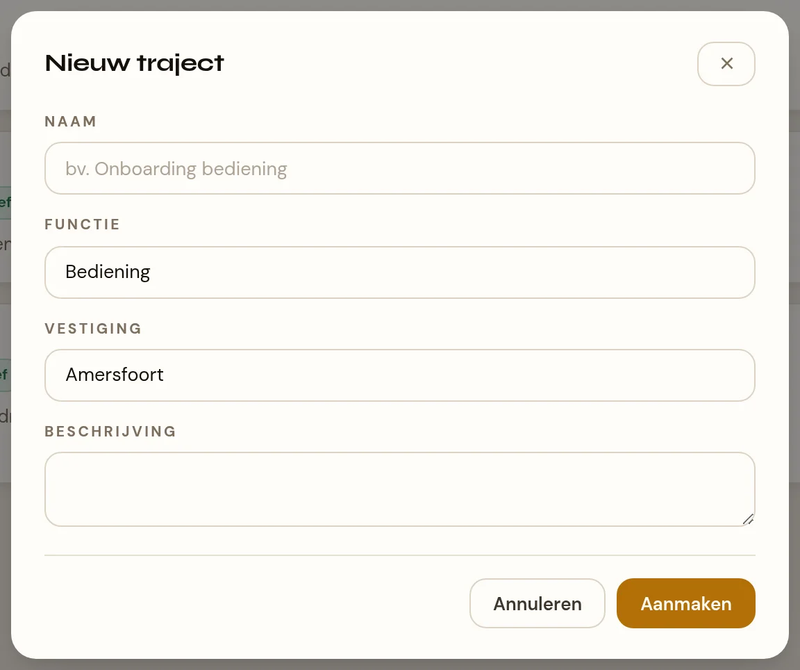 Een venster met de kop Nieuw traject. Van boven naar beneden: een tekstveld Naam met de voorbeeldtekst "bv. Onboarding bediening", een keuzelijst Functie die op Bediening staat, een keuzelijst Vestiging die het filiaal uit de balk heeft overgenomen, en een groot leeg tekstvlak Beschrijving. Onderin de knoppen Annuleren en Aanmaken.