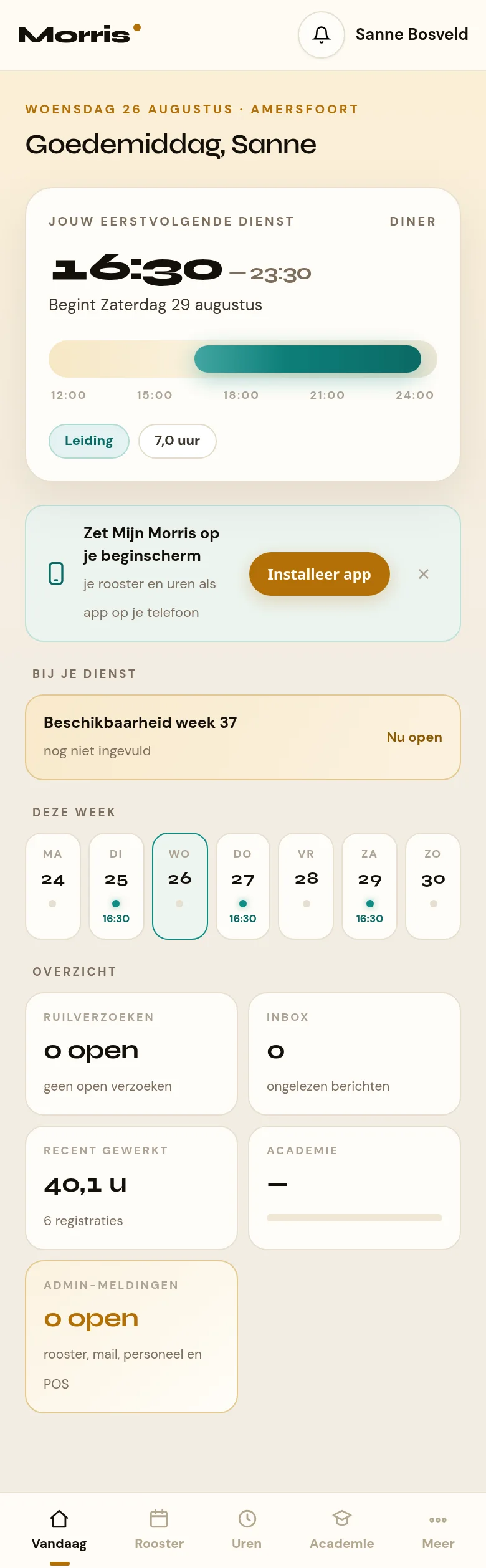 Het startscherm van het medewerkersportaal op een telefoon. Bovenin de balk met Morris, de meldingenbel en de naam. Daaronder de begroeting met de datum, en de witte dienstkaart met de begintijd groot, de aftelregel en de daglijn. Onderaan de tabbalk met Vandaag, Rooster, Uren, Academie en Meer.